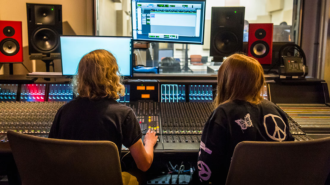 two students at audio foley effects board looking at computer monitors