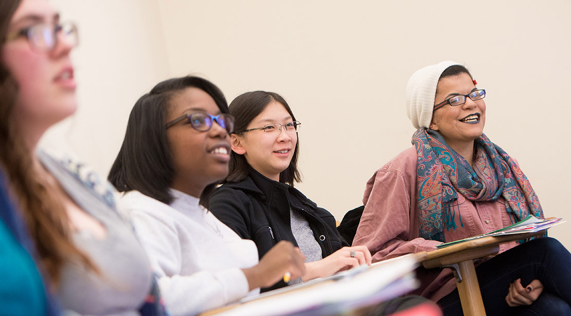 Four female students smiling in a classroom