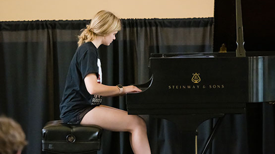middle-school student playing piano