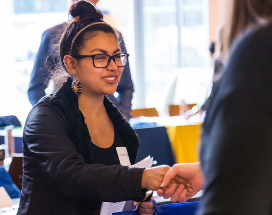 student shaking hand with recruiter