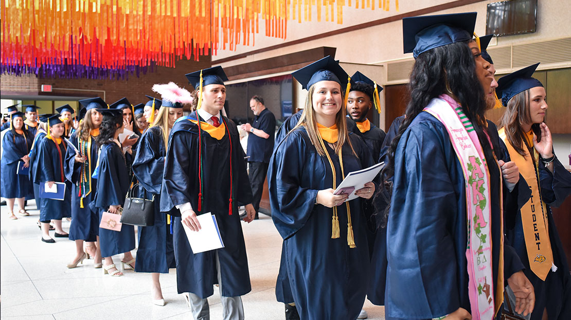 Webster students in graduation regalia lined up for Commencement