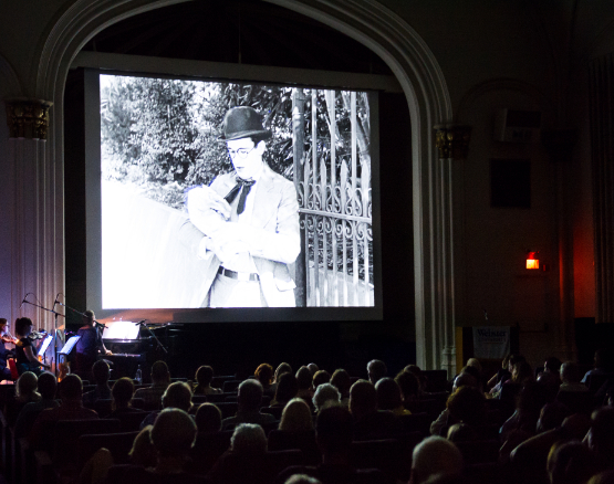 A Charlie Chaplin film plays during a Film Series screening.