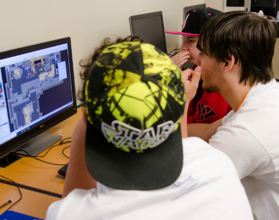Three students watch a video game.