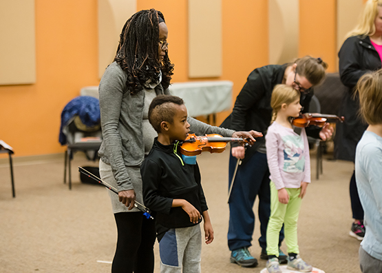 Suzuki students with moms learning violin