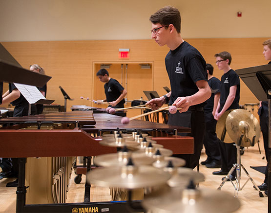 young man in glasses playing marimba