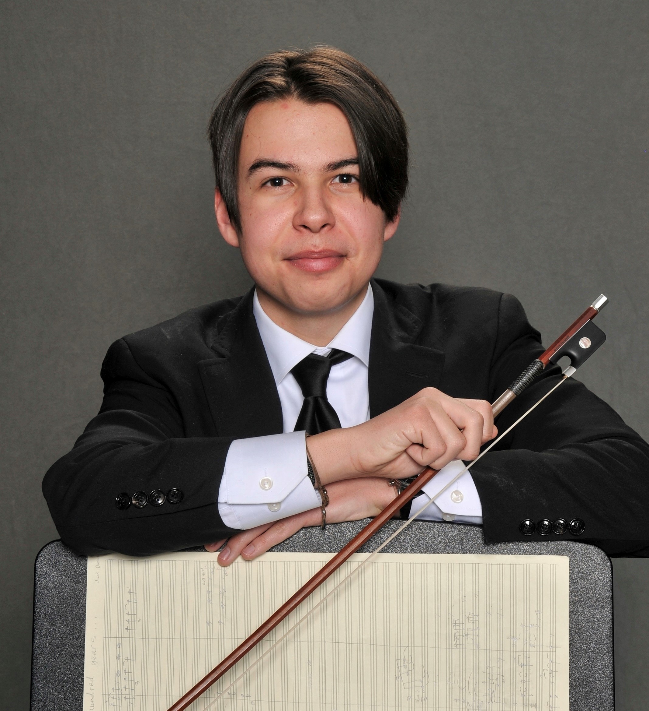 young man in suit holding cello bow