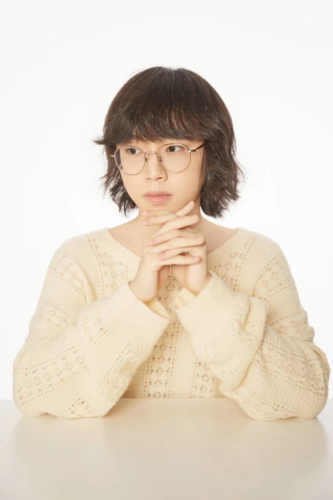 young asian woman with glasses with hands folded