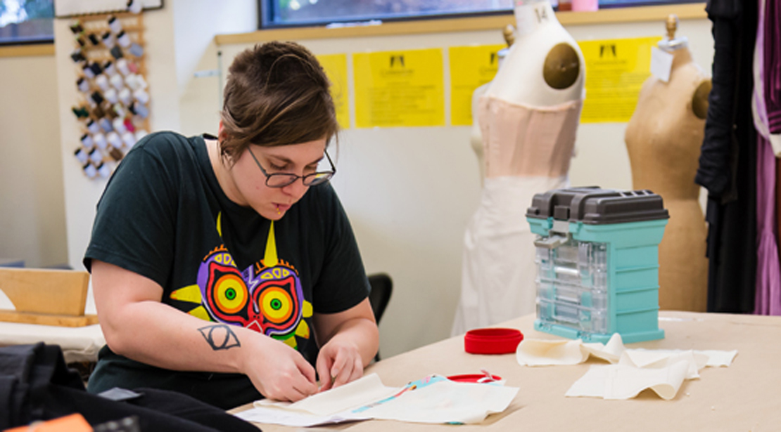 A student working with fabric for costume construction.