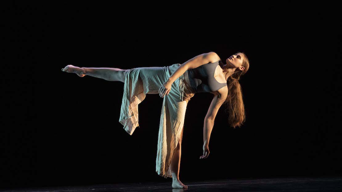 A dancer, leaning to the side with leg outstretched. A performer of modern dance.