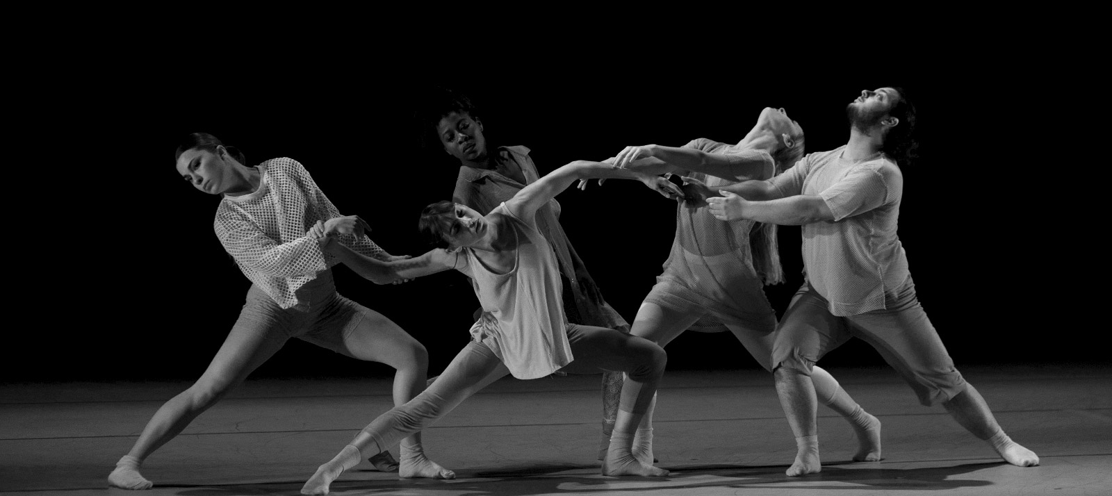 Five dances students moving rhythmically together.