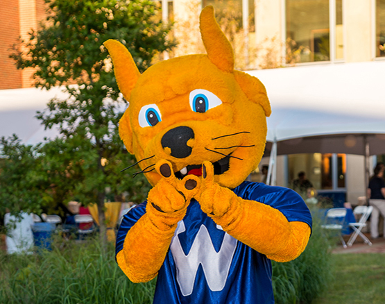 Gorlok mascot forming a W with its hands.