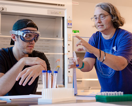 A student and a teacher working in the biology lab