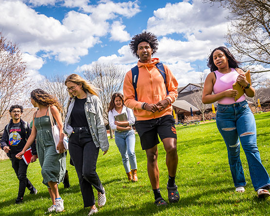 Webster students walking on campus green